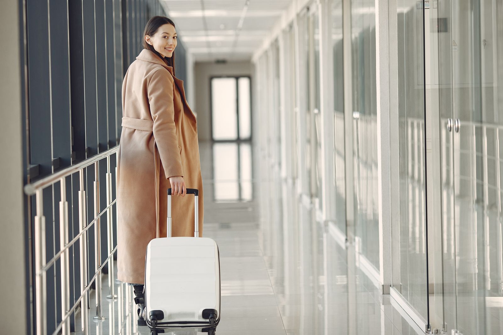 Traveller with a suitcase in a bright airport walkway
