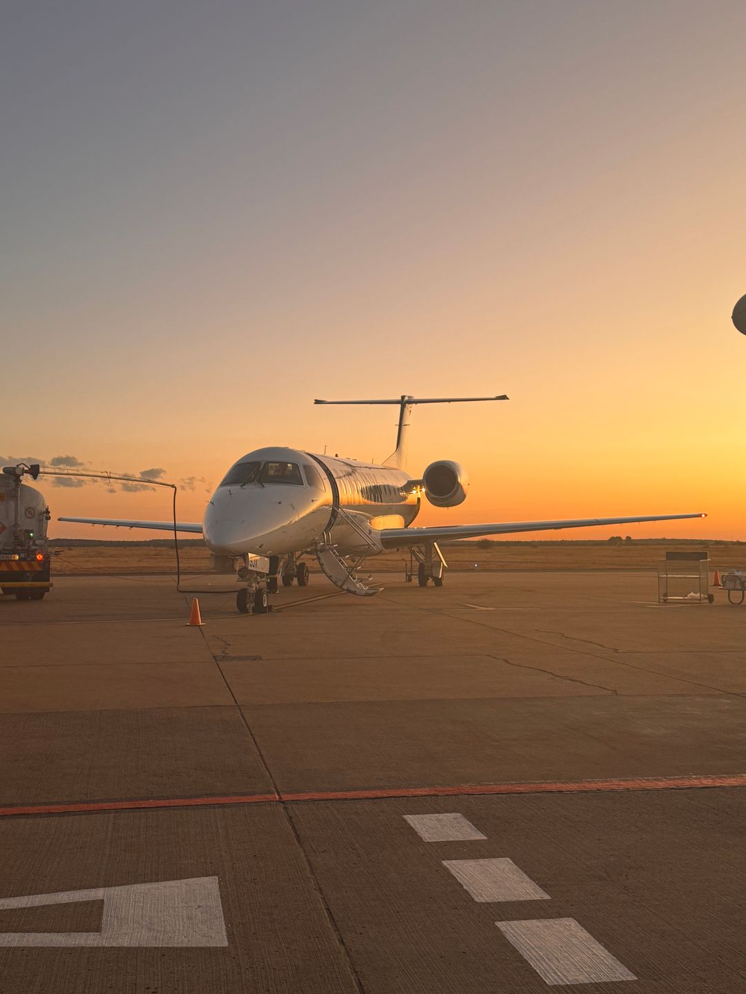 A private jet on the tarmac at sunset
